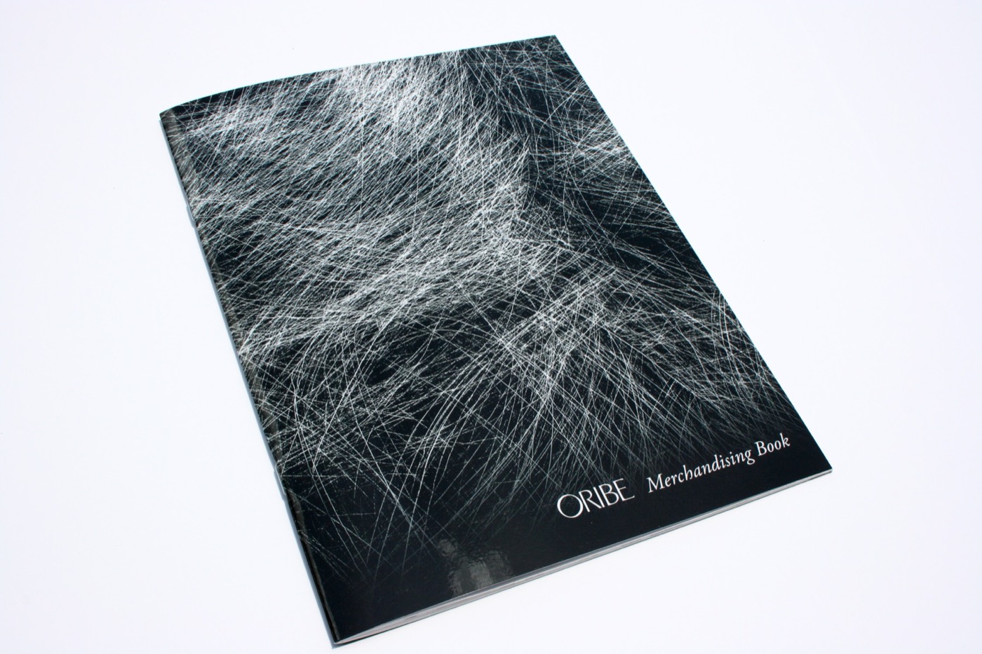 A black perfect-bound merchandising book with fine white line art